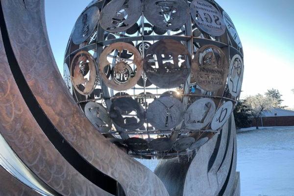 A sculpture of a sphere with persony different symbols